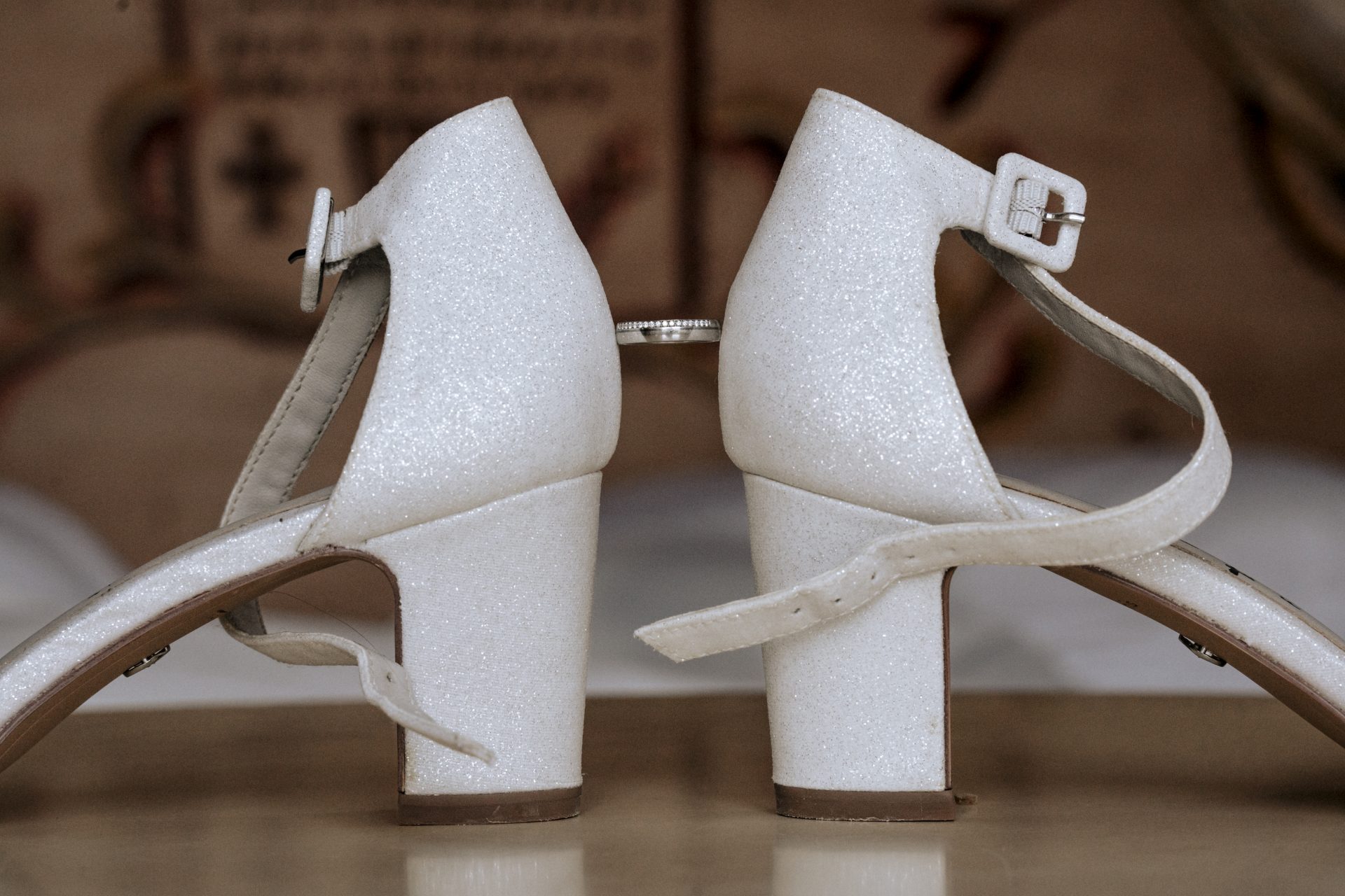 Glitzernde Brautschuhe mit Blockabsatz, dazwischen ein Ehering